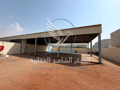**حوطة صناعية للإيجار في الصجعة | 10,000 قدم | شارع رئيسي | مظلة 2,500 قدم | إنترلوك كامل**