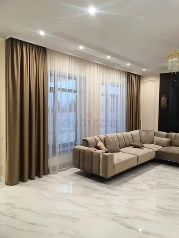 Floor-to-ceiling beige blackout curtains with sheer liners