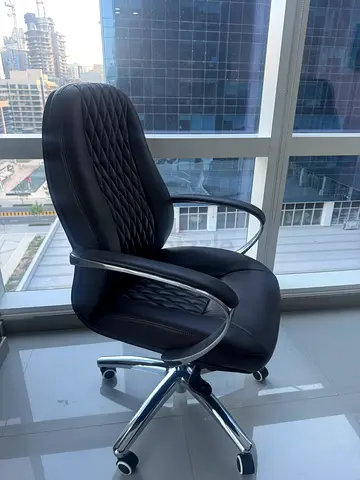 Dark brown leather swivel office chair with chrome arms and base