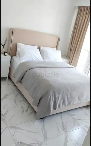 Beige upholstered queen bed with headboard and base