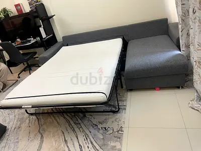 Grey L-shaped sofa with pull-out bed - good condition