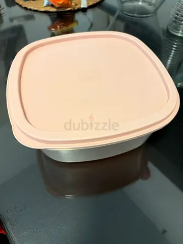 Used plastic food storage container with lid and measuring cups