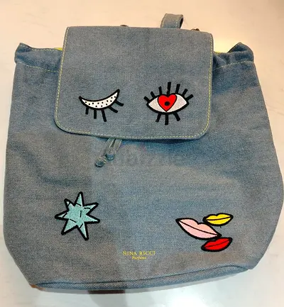 Light blue denim Nina Ricci backpack with embroidered patches