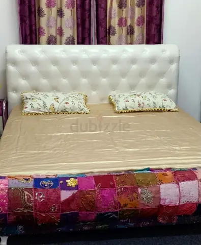 White tufted king-size bed with headboard and mattress