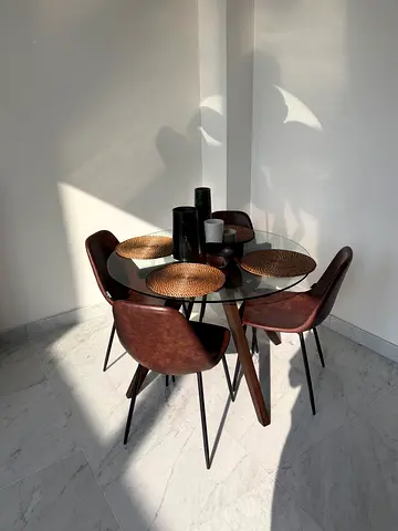 Modern glass-top dining table with 4 brown upholstered chairs