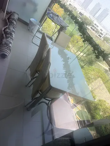 Compact dining table with 4 cream chairs - good used condition. Leaving the country wanted it gone