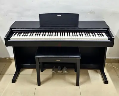 The Yamaha Arius YDP-103B is an 88-key, entry-level digital console piano featuring a black finish,