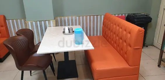 Orange tufted booth seating with marble-top dining table (set)
