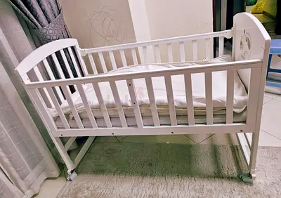 White wooden baby bassinet/crib on wheels, gently used