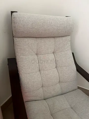 Light grey upholstered lounge chair with wooden frame