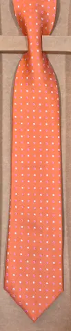 Orange men's silk tie with small white polka dots