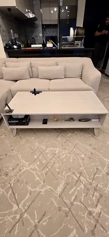 Light beige L-shaped sofa with matching coffee table and patterned rug