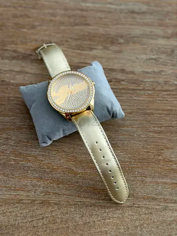Gold-tone women's watch with crystal-studded dial and leather strap