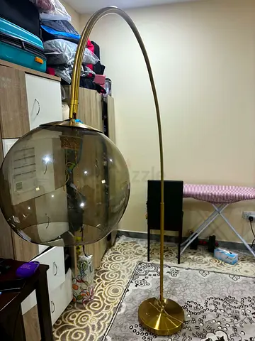 Brass arc floor lamp with smoked glass globe shade
