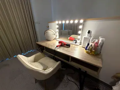 Wall-mounted vanity table with lighted mirror and chair