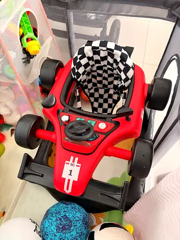 Red toddler ride-on racing car with steering wheel and seat
