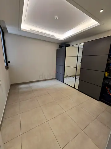 Modern Grey Wardrobe with Mirrored Sliding Doors. Ikea PAX with multiple shelves, drawer, and rods