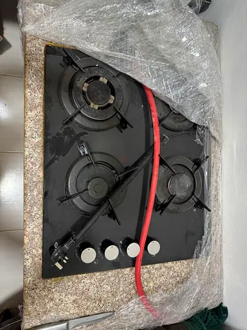 Table top gas stove with regulator, pipe and kitchen cabinet, stone tile