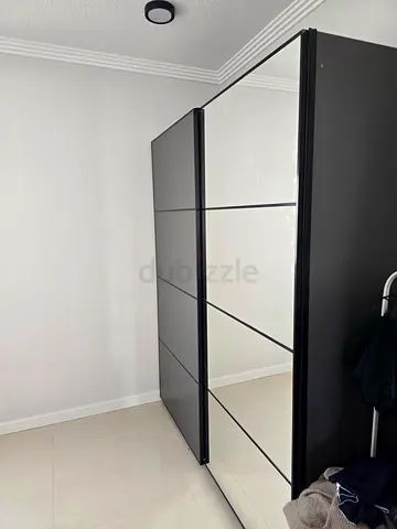 Modern Grey Wardrobe with 2 Mirrored Sliding Doors. Ikea PAX with multiple shelves, drawer, and rods