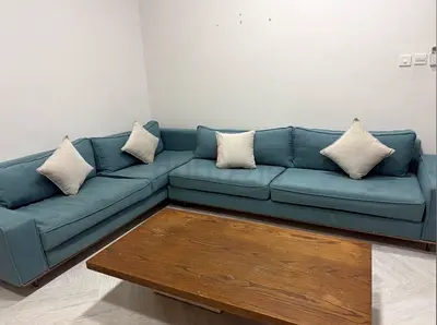 L-shaped 5-seater blue fabric corner sofa with cushions and table