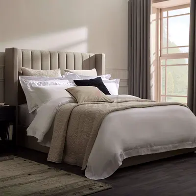 King-size upholstered bed with tall channel-tufted headboard