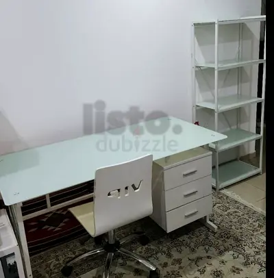 White glass-top office desk with drawers, matching shelving unit and chair