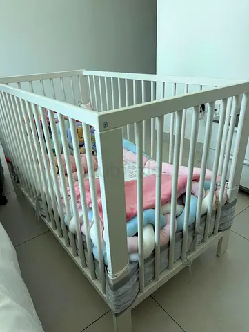 White wooden baby crib with mattress
