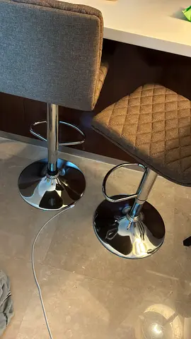 Pair of adjustable modern chrome bar stools with grey quilted seats
