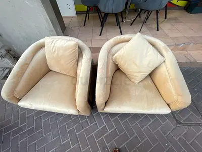 Pair of beige velvet single armchairs with cushions - used