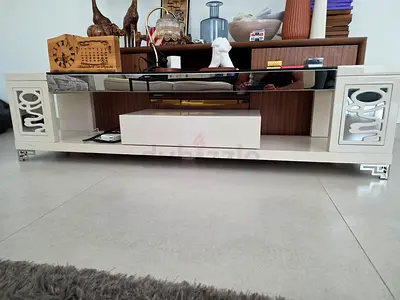 White glossy TV unit with mirrored top and storage cabinets