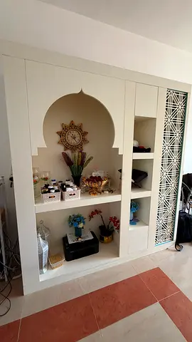 Built-in decorative wall shelving unit with Arabic arch design