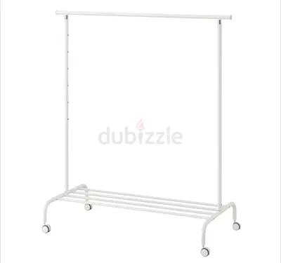 White metal clothes rack on wheels with bottom shelf