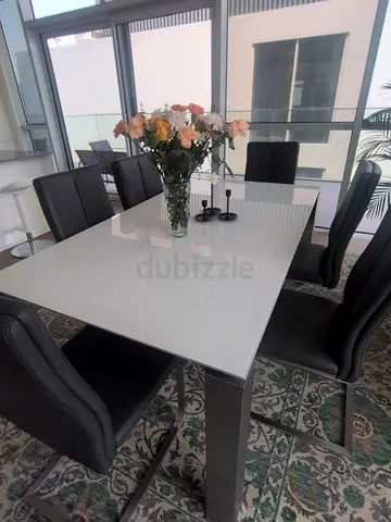White glass-top dining table with 6 black chairs - good condition