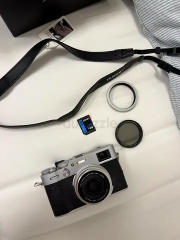 Fujifilm X100-series style compact camera with accessories