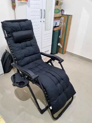 Black reclining zero gravity lounge chair with cushion and cup holder