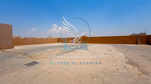 حوش 10,000 قدم مربع في الصجعة | شارع رئيسي | مكتب وحمام | إنترلوك كامل