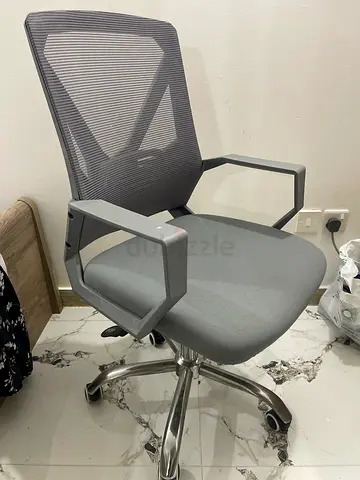 Grey ergonomic mesh office chair with armrests and swivel base