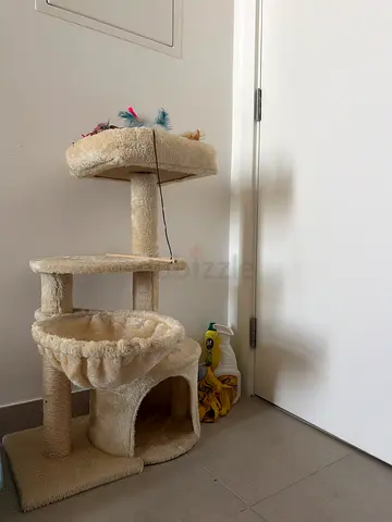 Beige multi-level cat tree with scratching posts and cozy condo