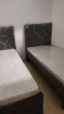 Two single beds with new mattresses and upholstered headboards