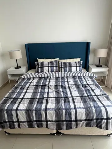 King bed with upholstered headboard and two bedside tables