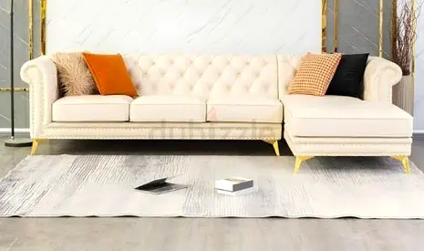 Cream tufted L-shaped sofa with gold legs — right-facing chaise
