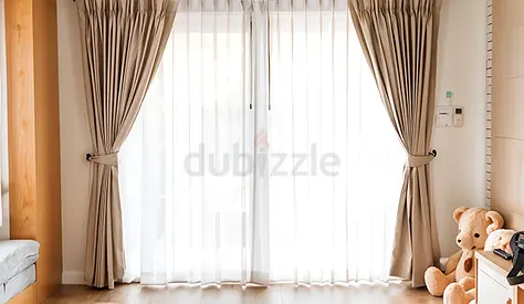 Beige floor-length curtains with white sheer panels makeyour space more premium