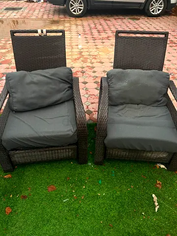 Pair of outdoor rattan lounge chairs with cushions