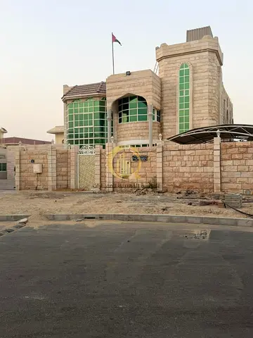 A villa in Al Ramaqiya, Wasit Suburb, Sharjah; the plot area is 13,200 square feet, and the villa is fully clad in stone.