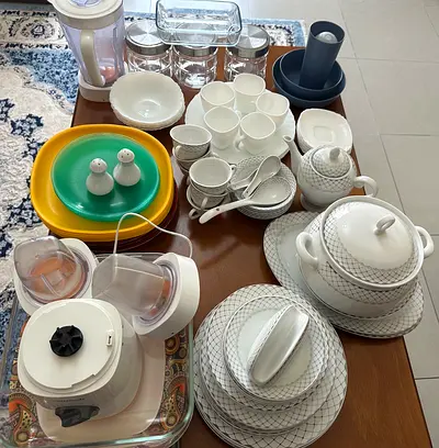 Mixed kitchenware set — dinnerware, glassware, blender, and serving pieces