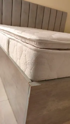 Single wooden bed frame with mattress and upholstered headboard