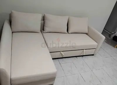Light beige L-shaped sofa with storage and cushions - good condition