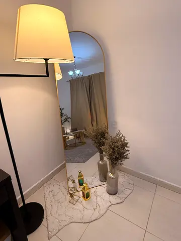 Modern style mirror with small white rug, ceramic floor vase and Arabic-style lanterns for sale