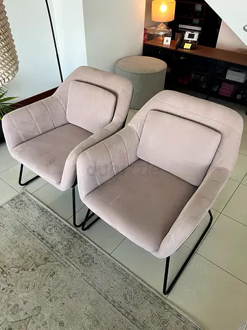 Pair of beige upholstered lounge chairs with metal legs