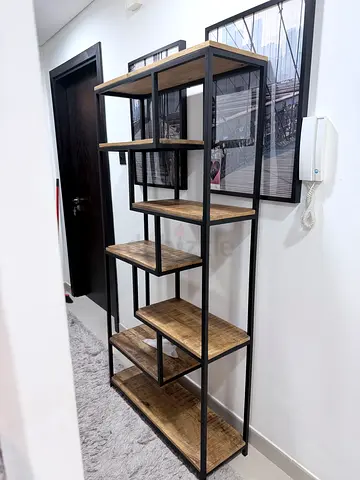 Industrial-style open shelving unit with wooden shelves and black metal frame